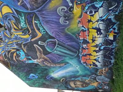 Graffeur encapuchonné et fresques colorées